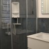 Lavabo bianco accanto a una doccia con porta in vetro.
