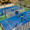 Campi da paddle blu con persone che giocano.