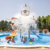 Bambini giocano sotto un secchio d'acqua che si rovescia.