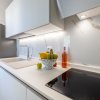 Cucina bianca elegante con frutta sul piano di lavoro.