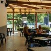 Veranda con tavoli e persone sedute all'aperto.