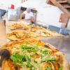 Pizza con rucola e scaglie di formaggio in una pizzeria.
