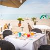 Tavolo apparecchiato su una terrazza vista mare con giochi sulla spiaggia.
