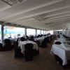 Ristorante con tavoli apparecchiati in riva al mare.