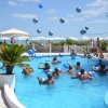 Persone giocano con palloni in piscina.