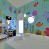 Camera con letto matrimoniale e murales marino.