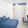 Camera da letto con arredi blu e pareti bianche, tende chiuse.