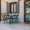 Patio esterno con tavolo e sedie verdi.