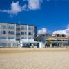 Edificio moderno fronte mare con cielo blu.