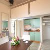 Cucina accogliente con tavolo, fiori e scala a chiocciola.