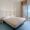 Camera da letto luminosa con letto matrimoniale e vista mare.