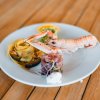 Piatto di pasta e frutti di mare su tavolo di legno.